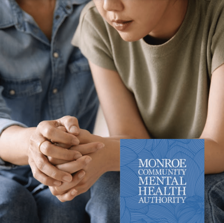 Person sitting holding hands with Monroe Community Mental Health Authority logo and graphic in lower right corner