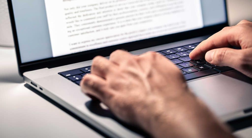closeup of hands typing on a laptop