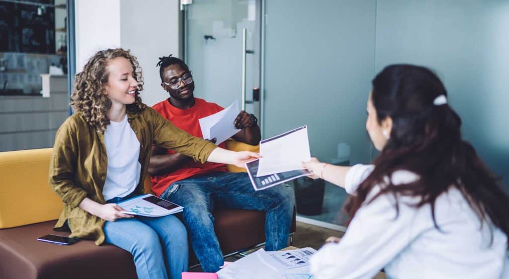 people exchanging paperwork in an office