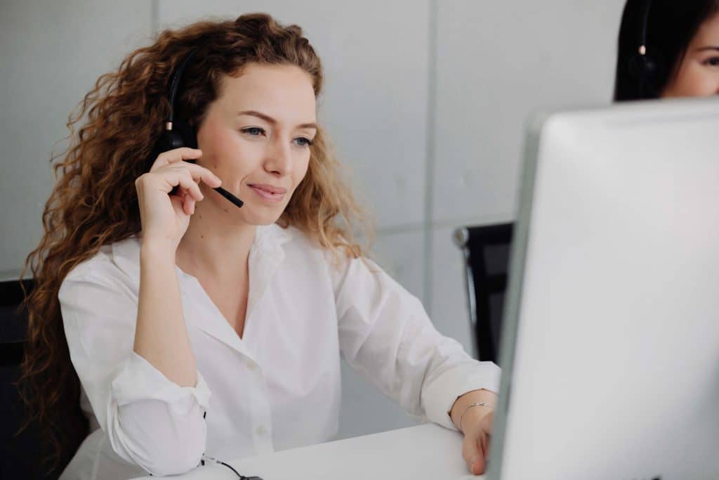 Lady with headset phone looking at computer